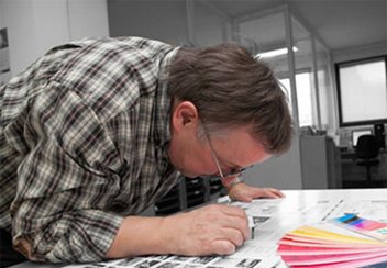 Мастер-технолог, сублимационной печати по ткани проверяет цветовую точность отпечатка
по цветовому вееру Pantone.