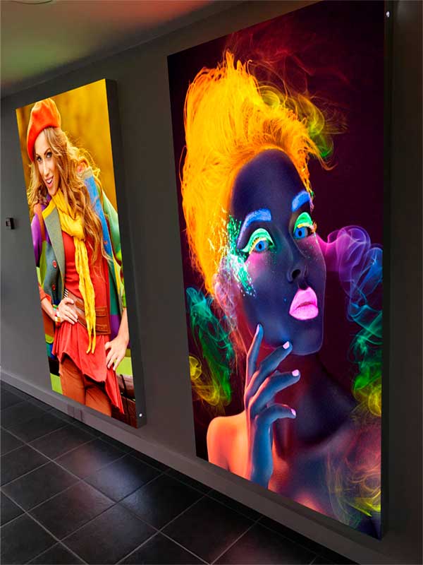 Два световых короба с яркими, четкими дизайнами на стене помещения.