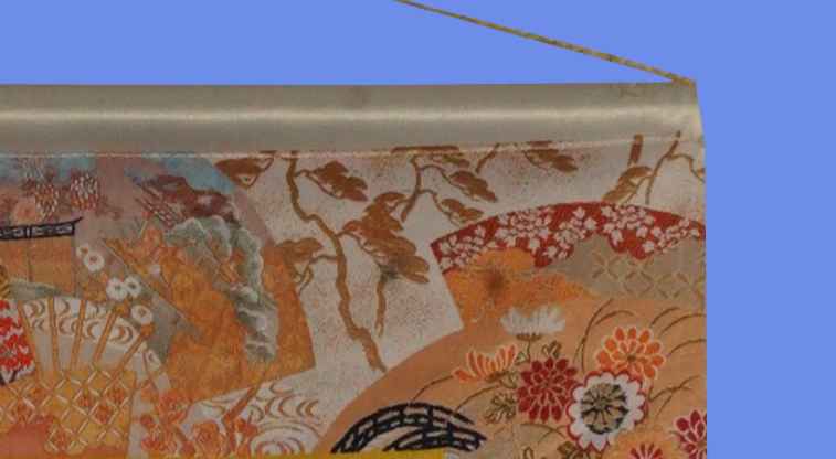 Подвешивание тканевого плаката на шнуре, продетом через пластиковую трубку, вставленную в карман по верхнему краю полотна